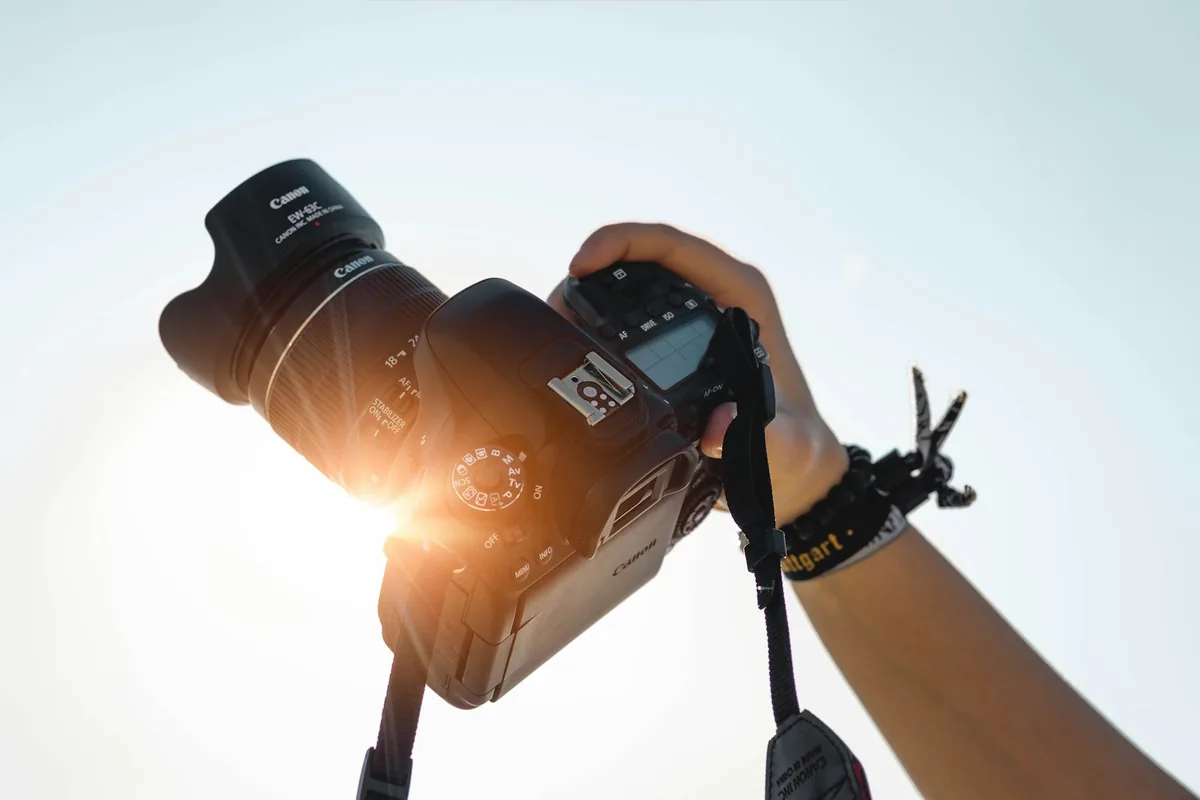 Hand holding a camera up against bright sunlight