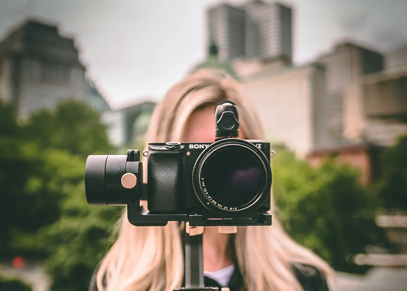 Person holding a mirrorless camera on a handheld gimbal stabilizer