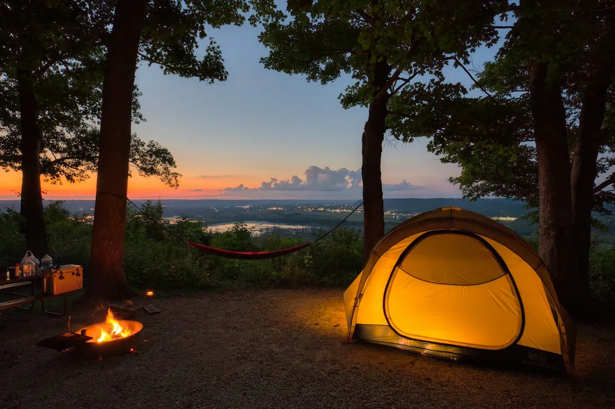 Zelt auf einem bewaldeten Campingplatz in der Abenddämmerung