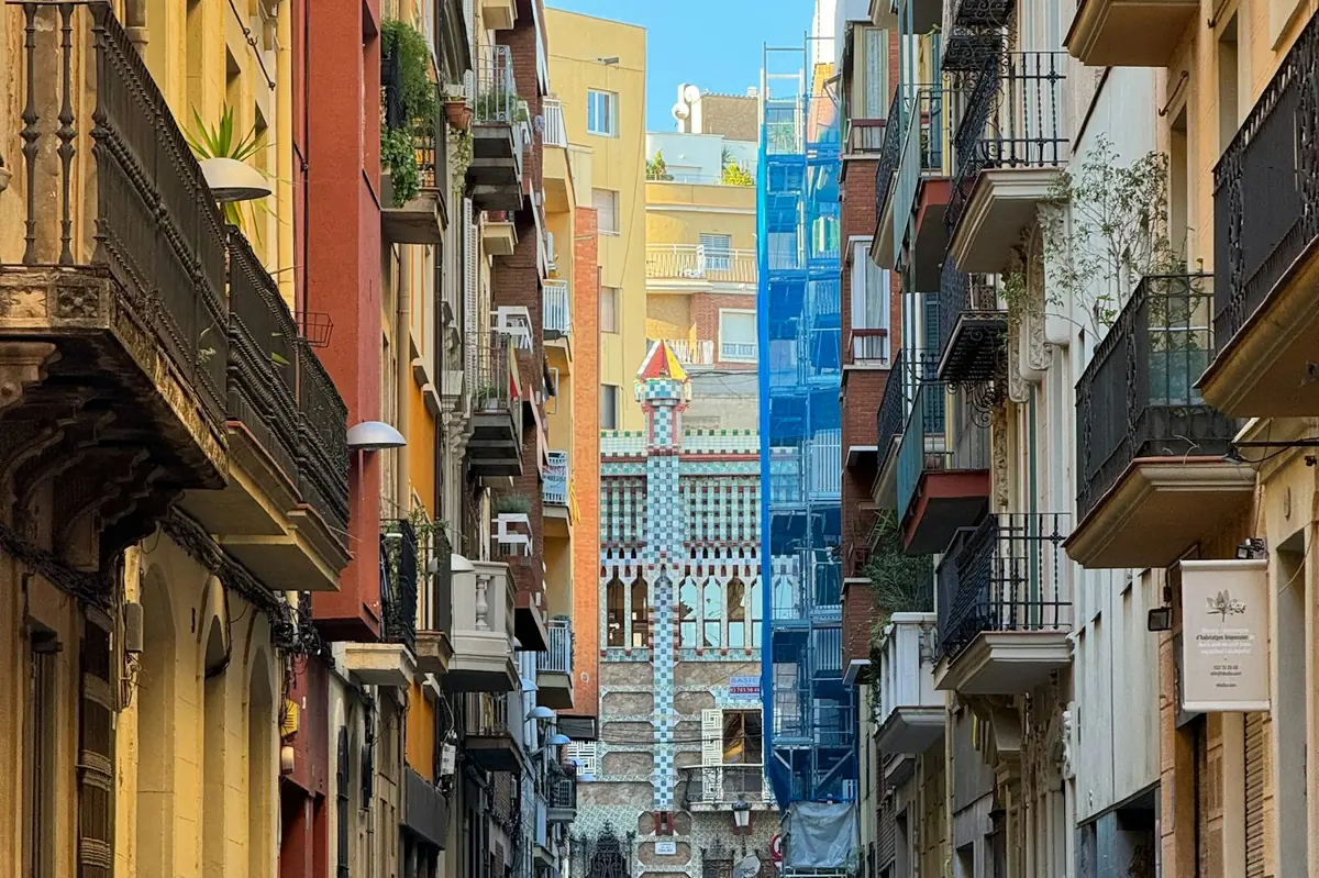 Narrow Barcelona street lined with tall colorful buildings, car hire in Spanish city centers