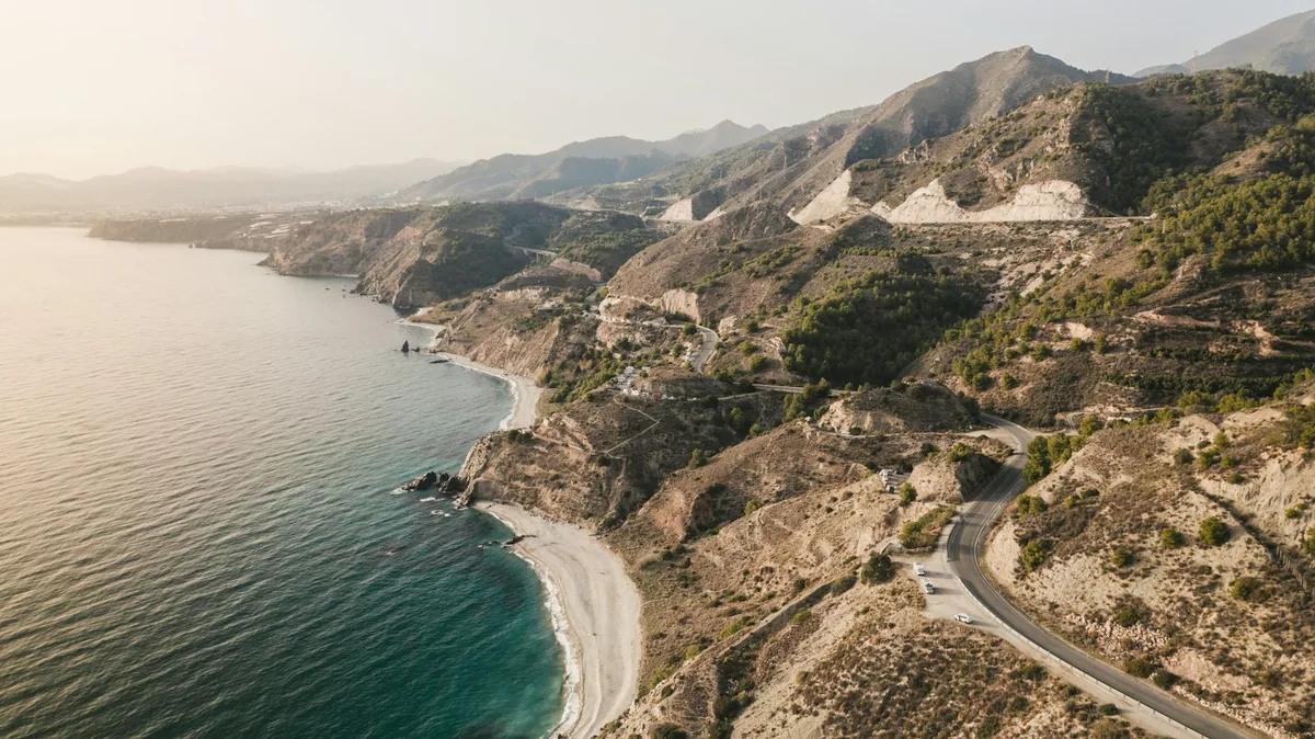 Aerial view of a coastal road and beach near Nerja, car hire in Spain