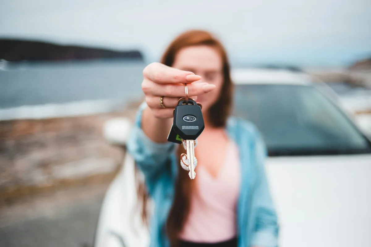 Hand holding a black car key, car rental deposit in Spain