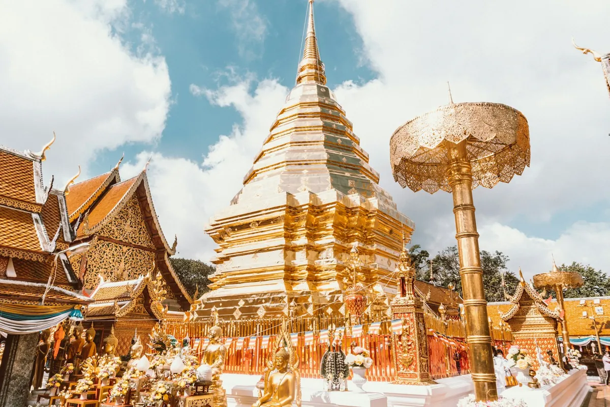Golden chedi at a Chiang Mai temple under a blue sky