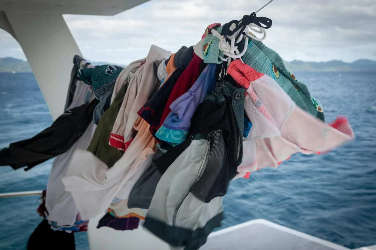 Kleren drogen aan een lijn op een boot, met de zee op de achtergrond