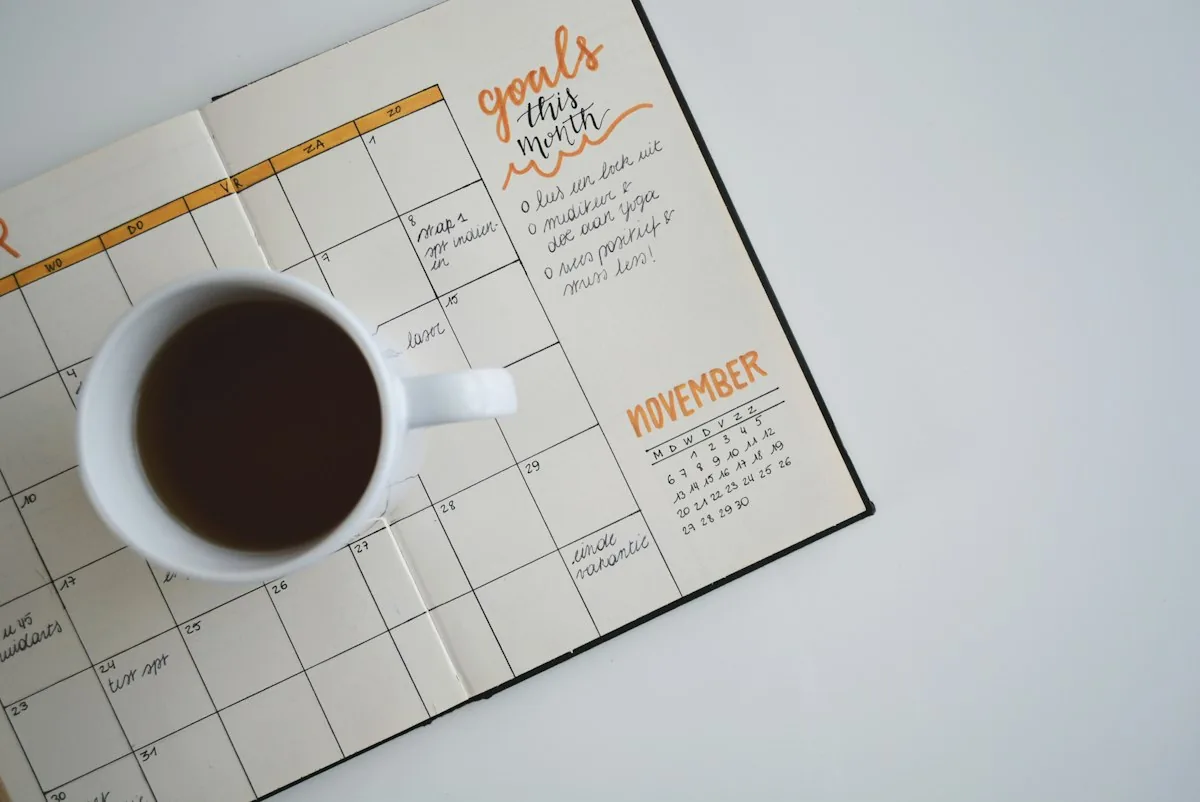 Black coffee in a white mug on a monthly planner page
