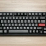 Compact black mechanical keyboard on a wooden table