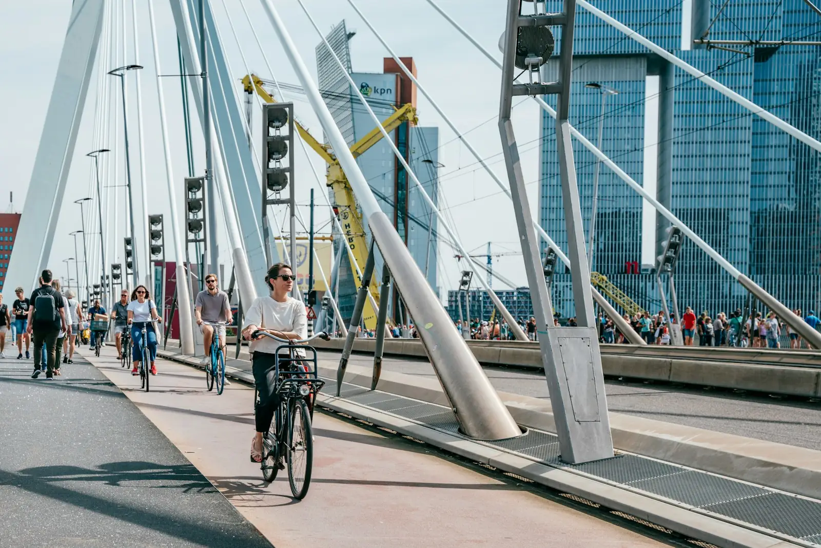 Cyclists and walkers crossing a cable-stayed bridge in a city