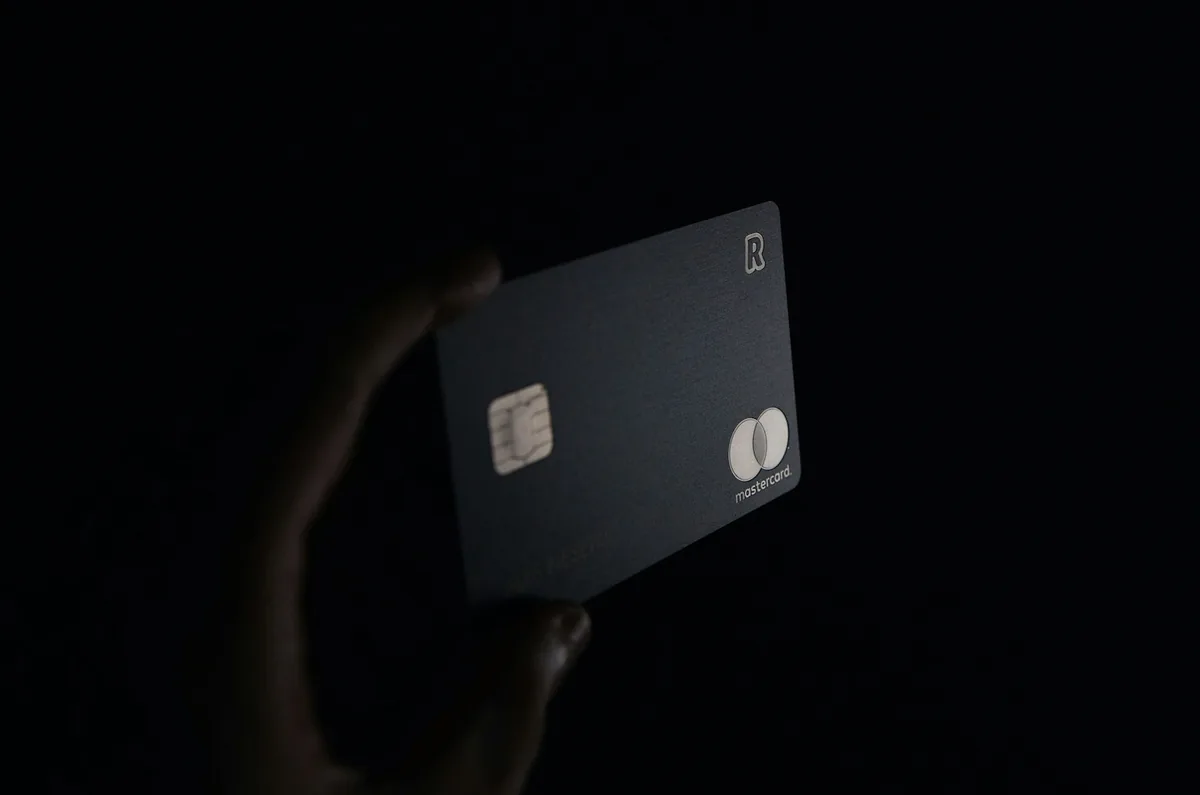 Hand holding a dark bank card in low light
