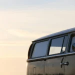 Dunkelgrauer Oldtimer-Campingbus mit getönten Scheiben im Abendlicht