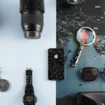 Camera lens, phone, watch and sunglasses on a world map, digital nomad packing list