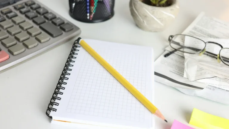 Calculator, notebook and pencil on a desk, digital nomad taxes and banking