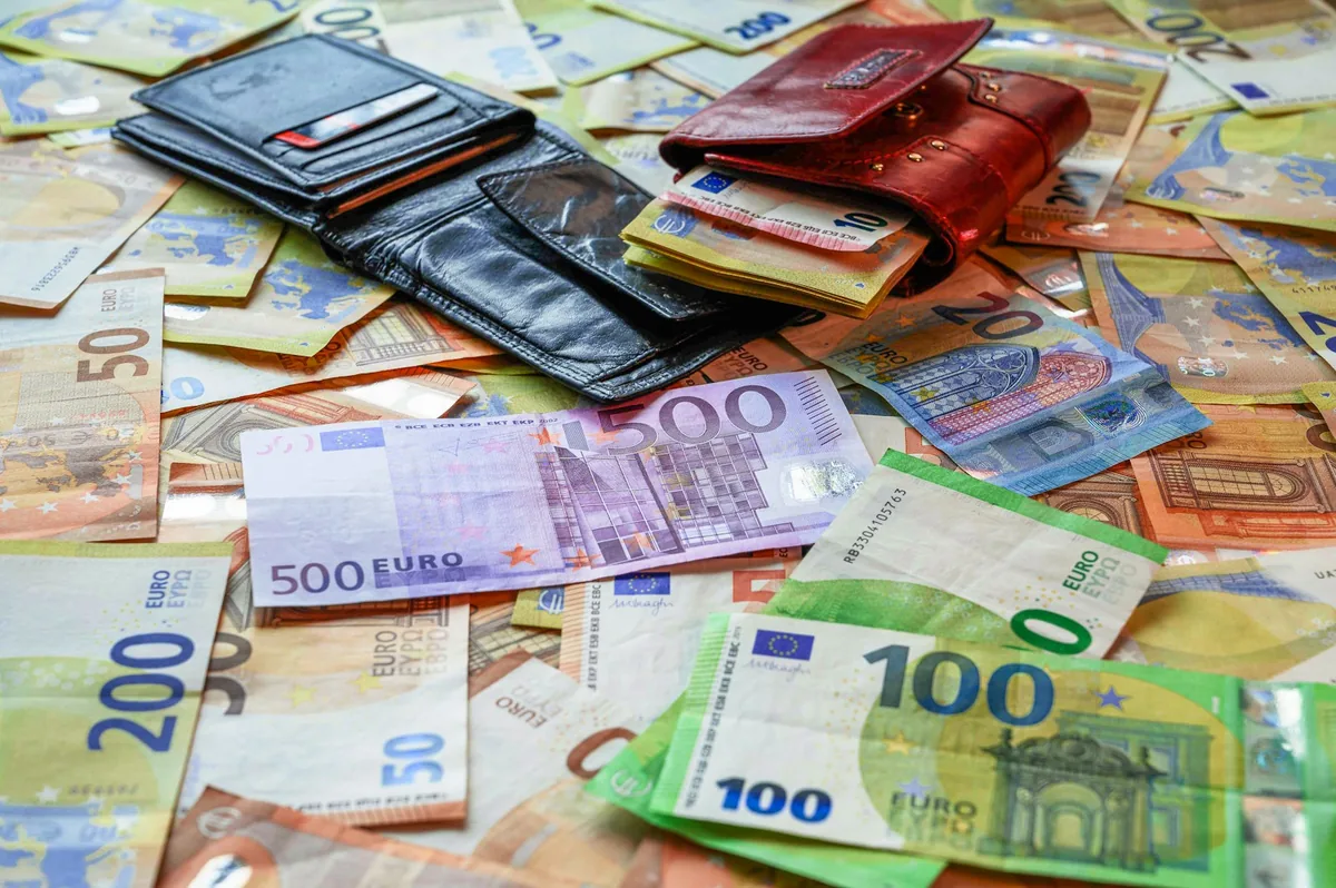 Pile of euro banknotes and wallets on a table