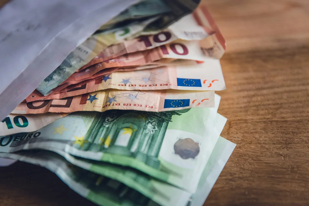 Euro banknotes spread out on a wooden table