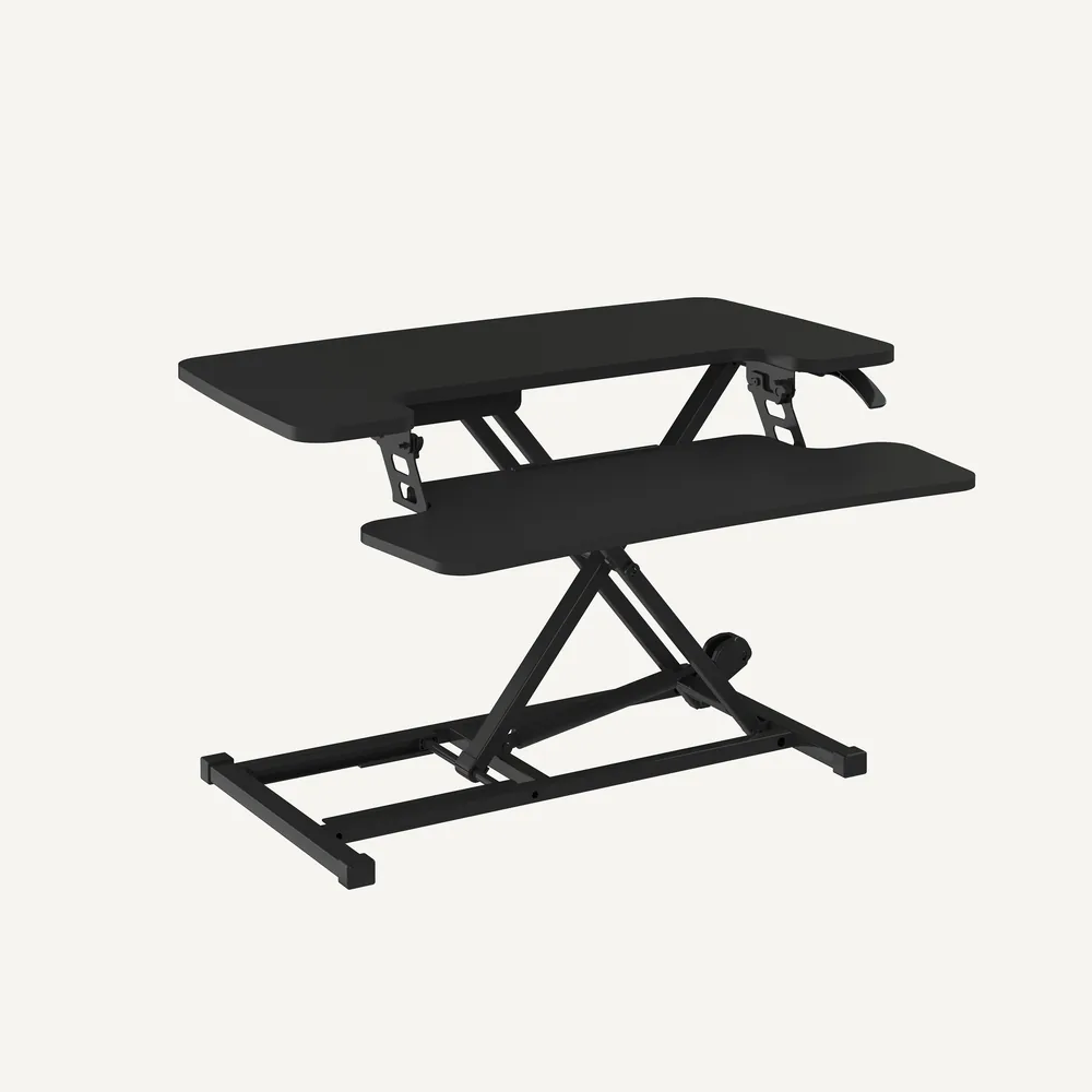 Flexispot AlcoveRiser M7 standing desk converter in black, raised, on an off-white background