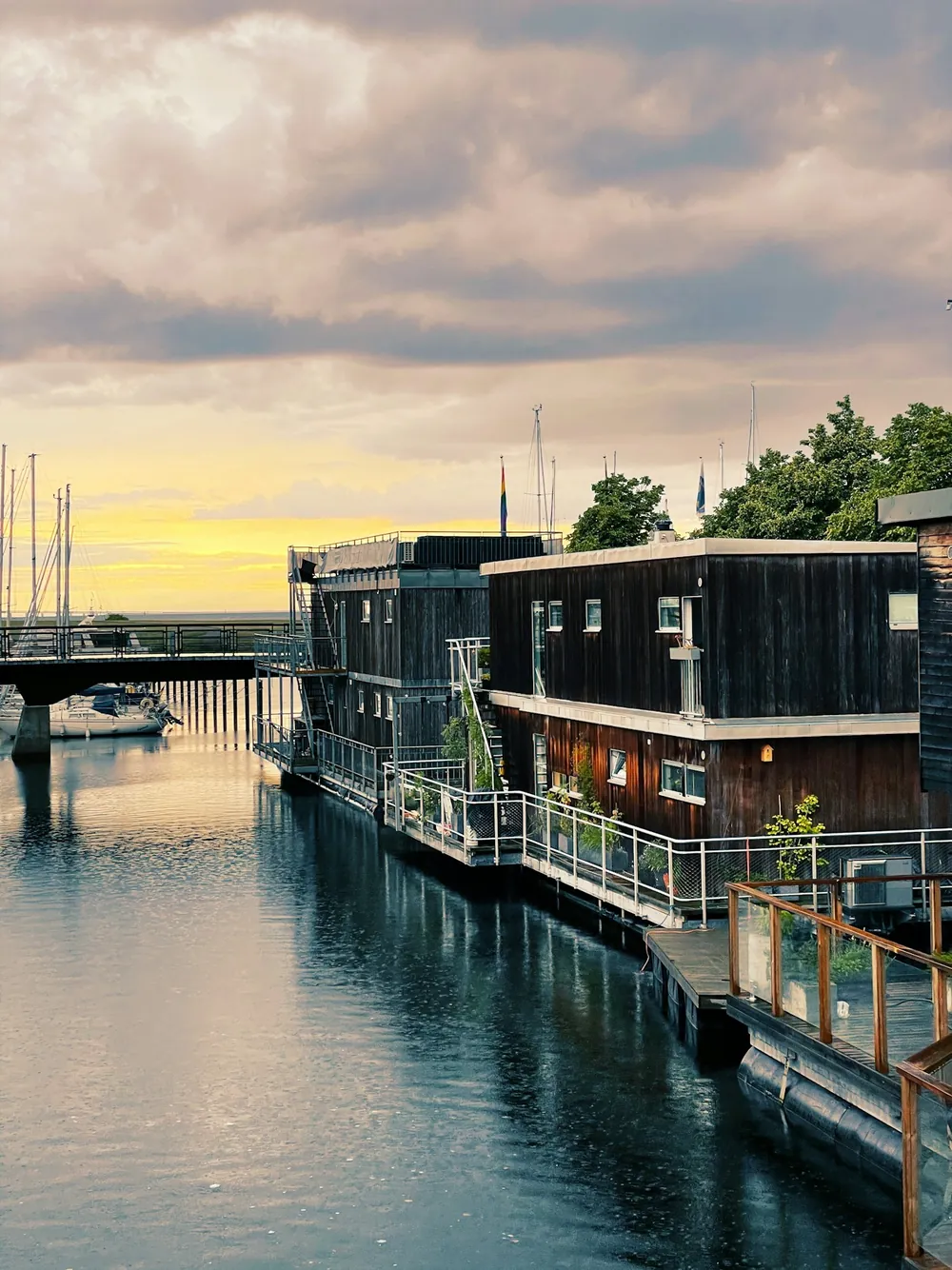 Floating homes moored along a river quay at dusk