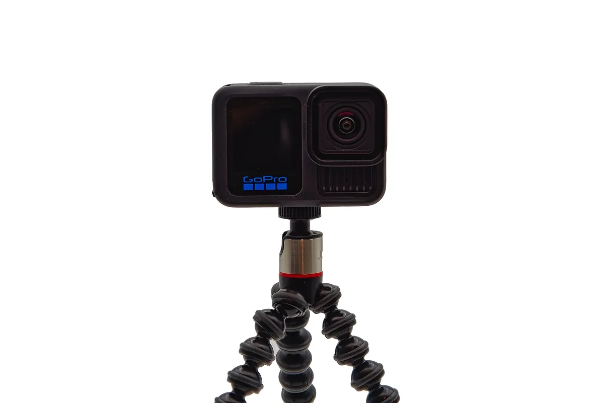 GoPro HERO13 Black auf einem kleinen flexiblen Stativ vor weißem Hintergrund