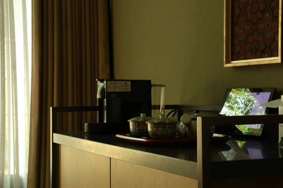 A hotel room counter with a kettle and a tea tray in soft light