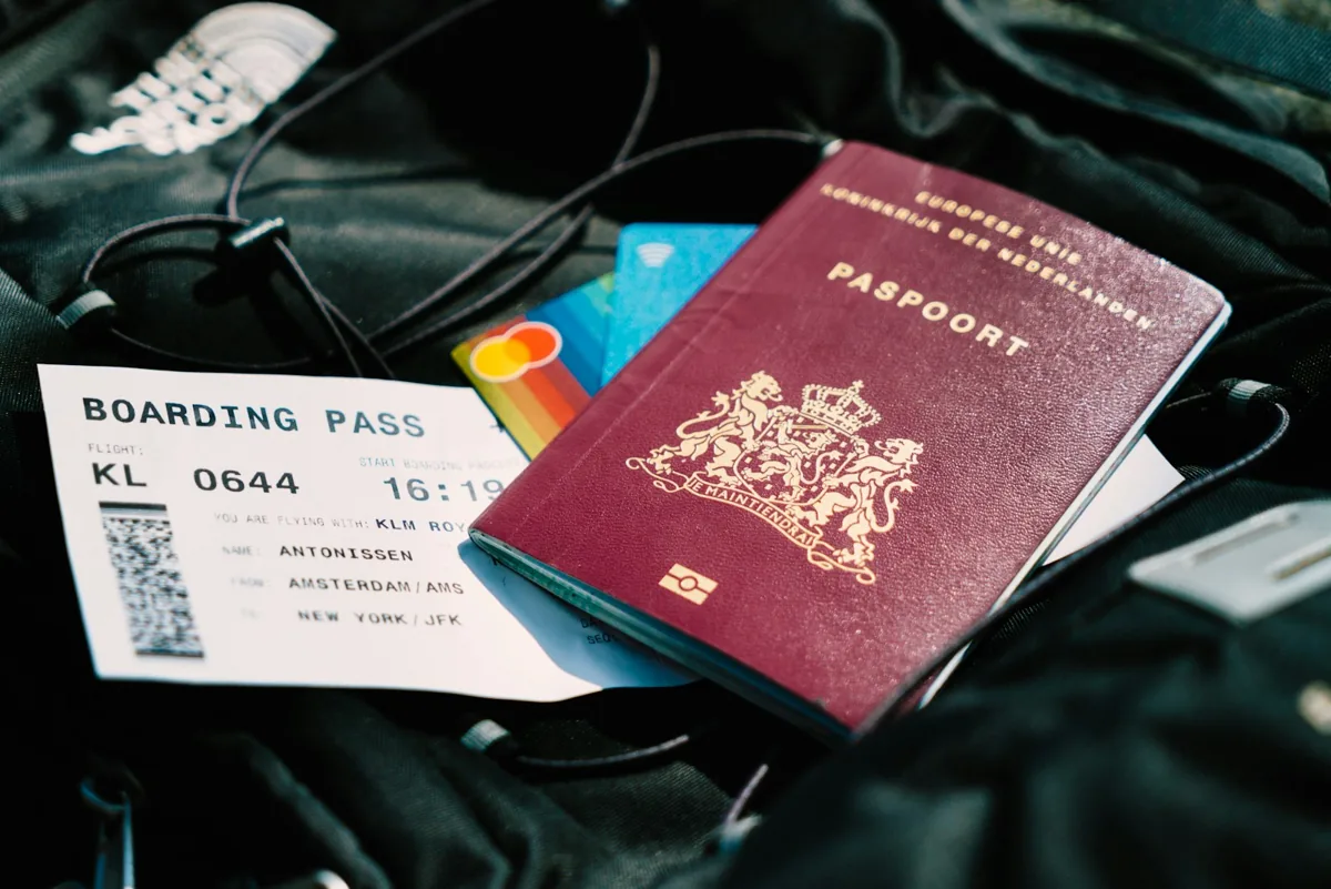 Pasaporte y tarjeta de embarque sobre una bolsa, junto con el carné de conducir y el permiso internacional de conducir con los documentos de viaje