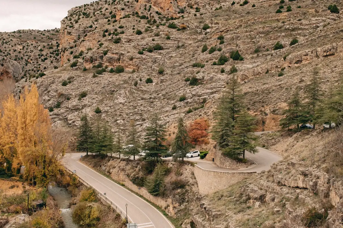 Winding road through autumn hillsides near Albarracin in Spain, international driving permit in Europe