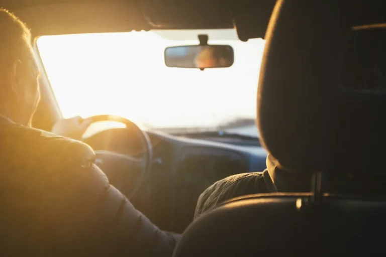 Driver's view inside a car with the sun low over the road, international driving permit