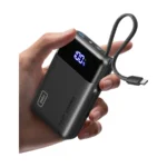 INIU Carry 20000mAh power bank in black held in a hand, with a built-in USB-C cable and display