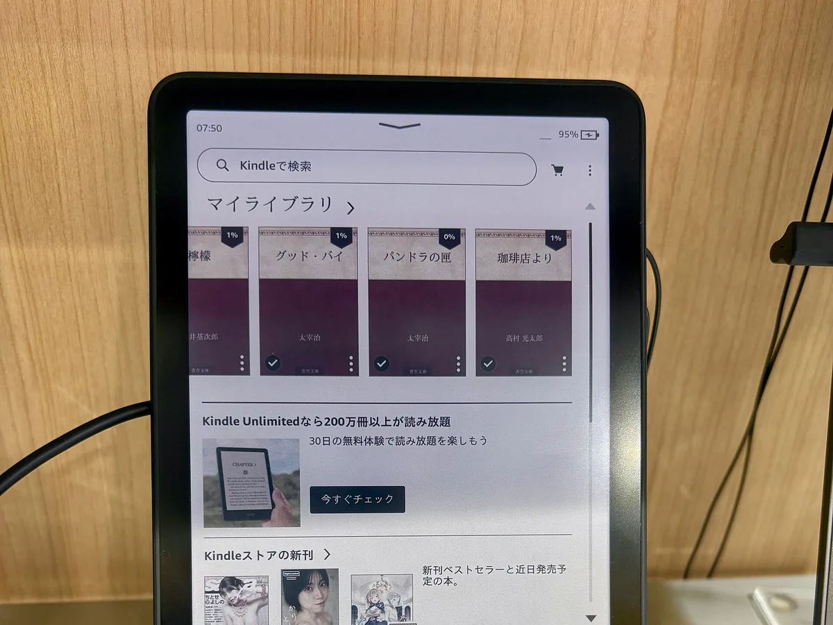 Kindle Colorsoft en un expositor de tienda mostrando una biblioteca con portadas de libros