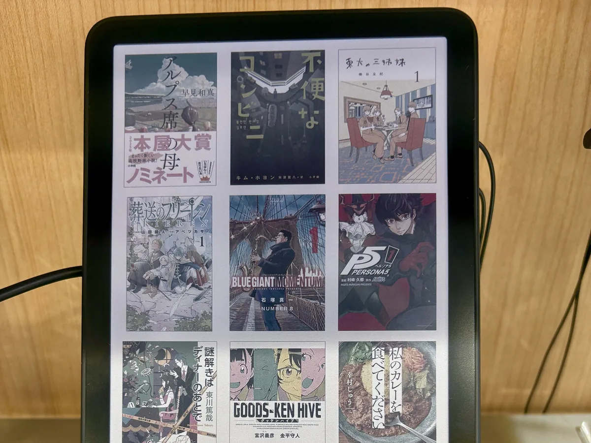 Kindle Colorsoft en un expositor de tienda mostrando una biblioteca de portadas de libros en color