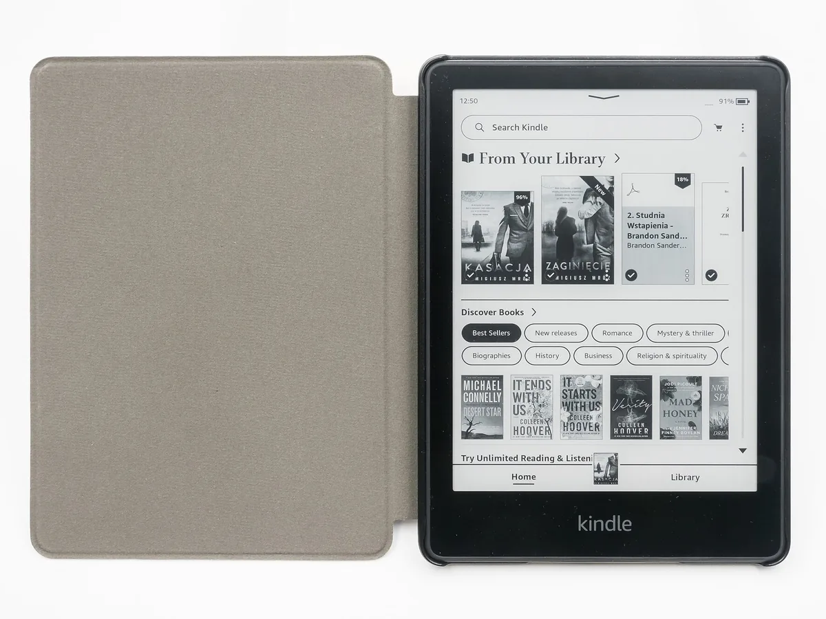 Kindle Paperwhite mostrando su pantalla de inicio junto a una funda gris abierta