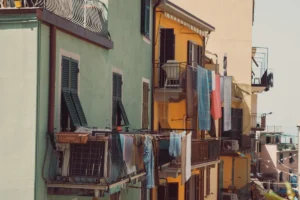 Laundry hanging from balconies on colourful houses in a coastal town