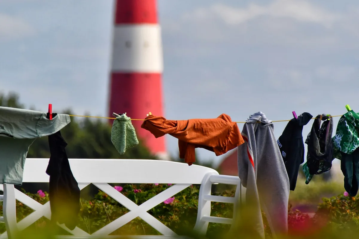 Was drogend aan een lijn in een tuin, met een rood-witte vuurtoren op de achtergrond
