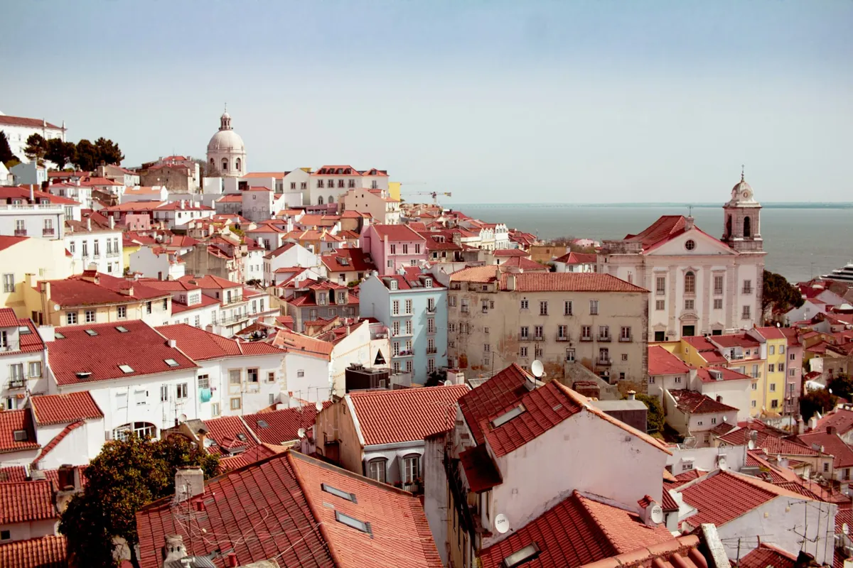 Lisbon rooftops and a church dome seen from a viewpoint