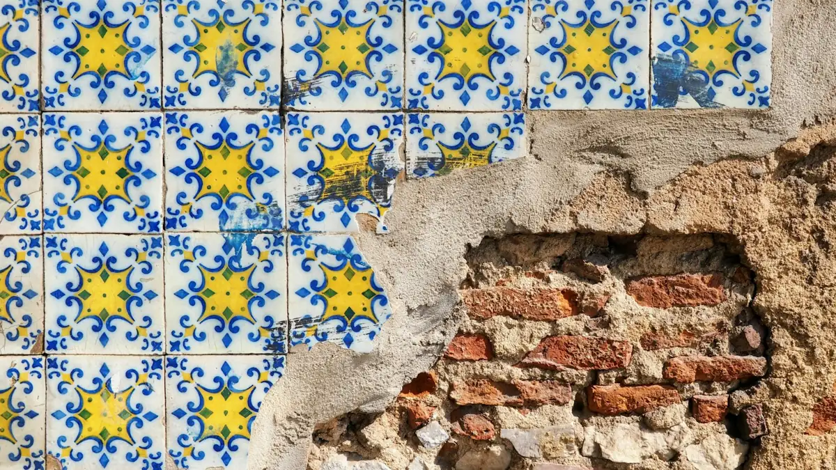 Blue and yellow azulejo tiles on a damaged wall in Lisbon