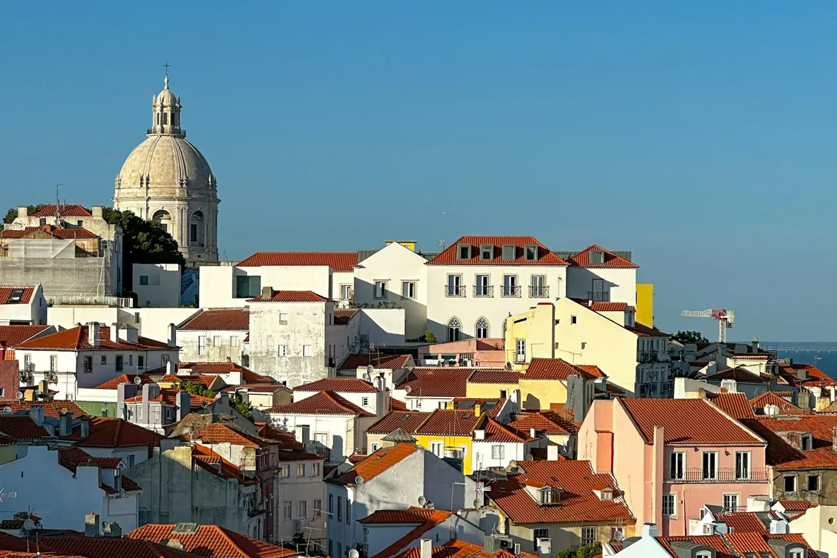 View over white and red rooftops in Lisbon with a church dome