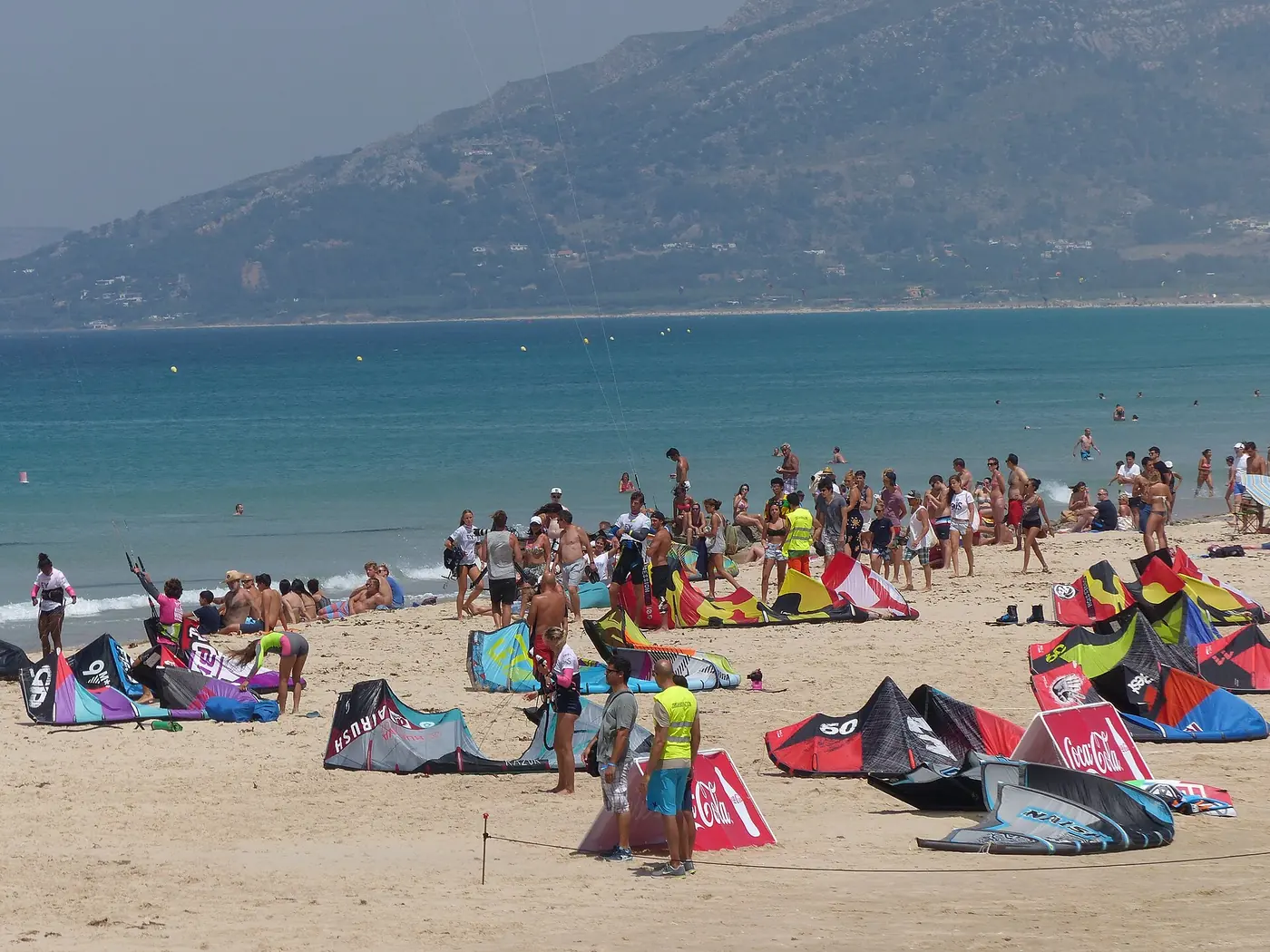 Kites laid out on the sand of Playa de Los Lances in Tarifa with the sea behind