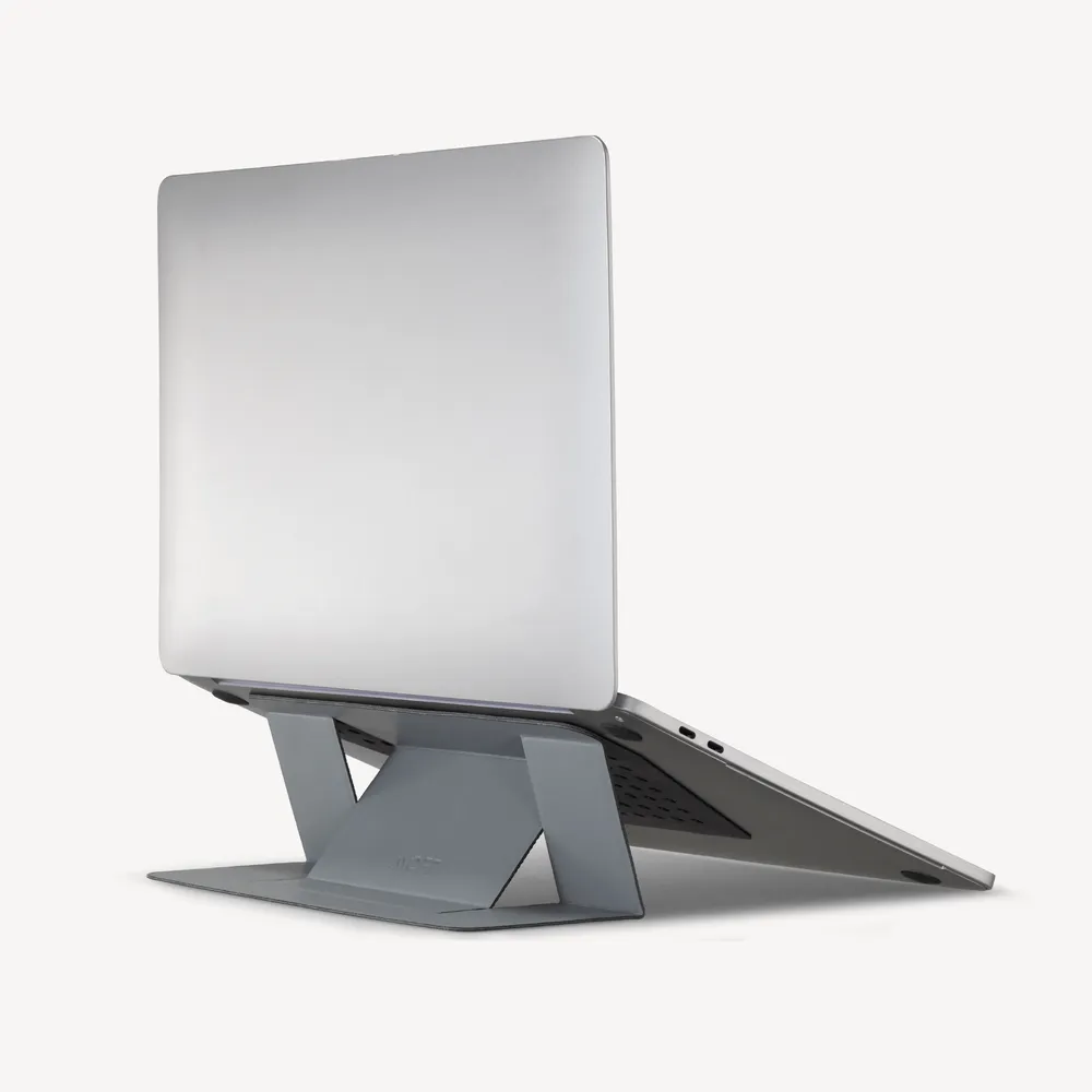 MOFT Invisible Laptop Stand in space gray holding a laptop at an angle