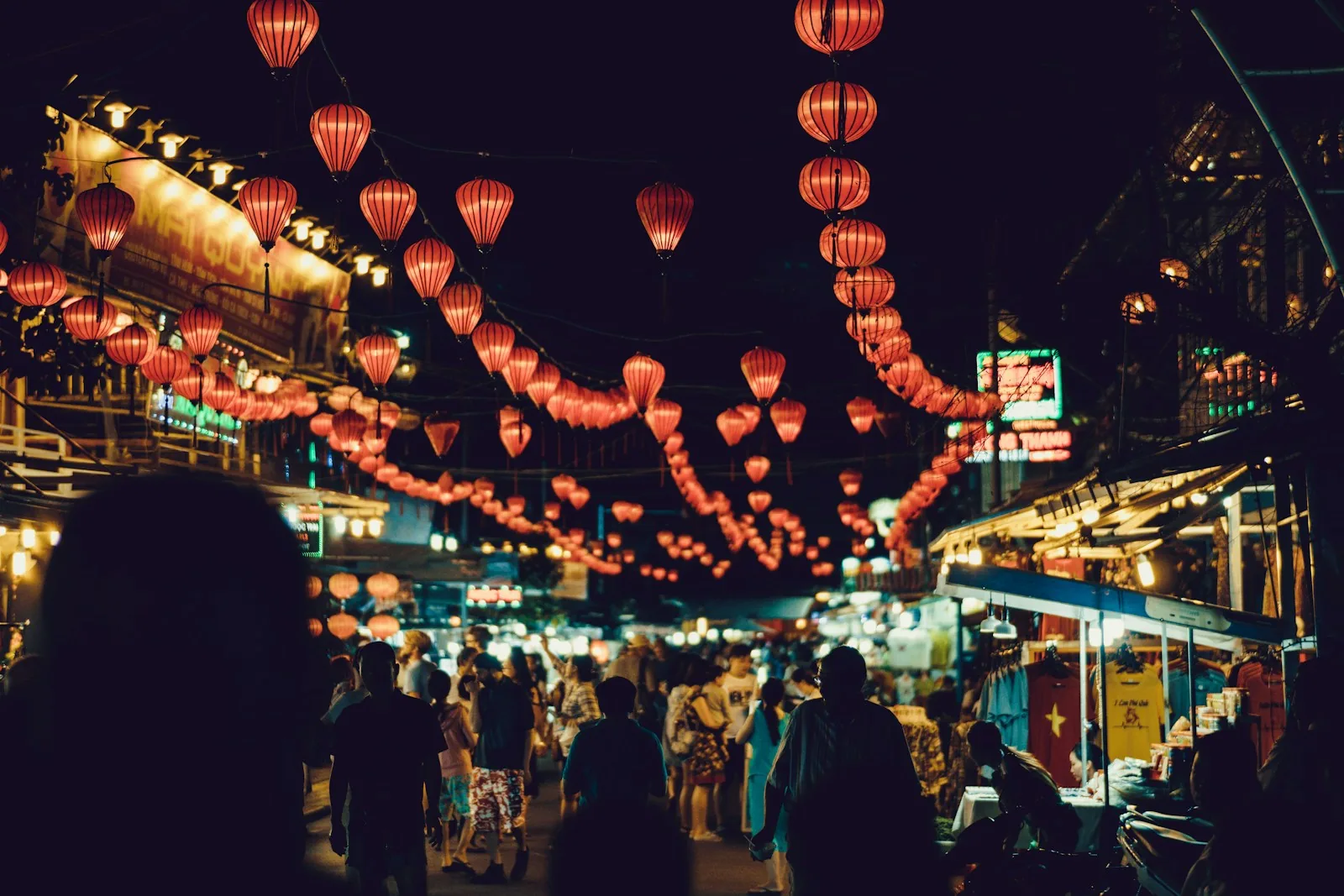 A crowded night market under red paper lanterns