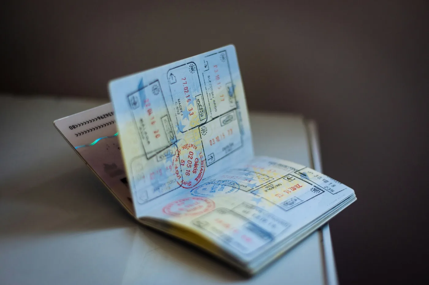 Open passport with many entry and visa stamps lying on a table
