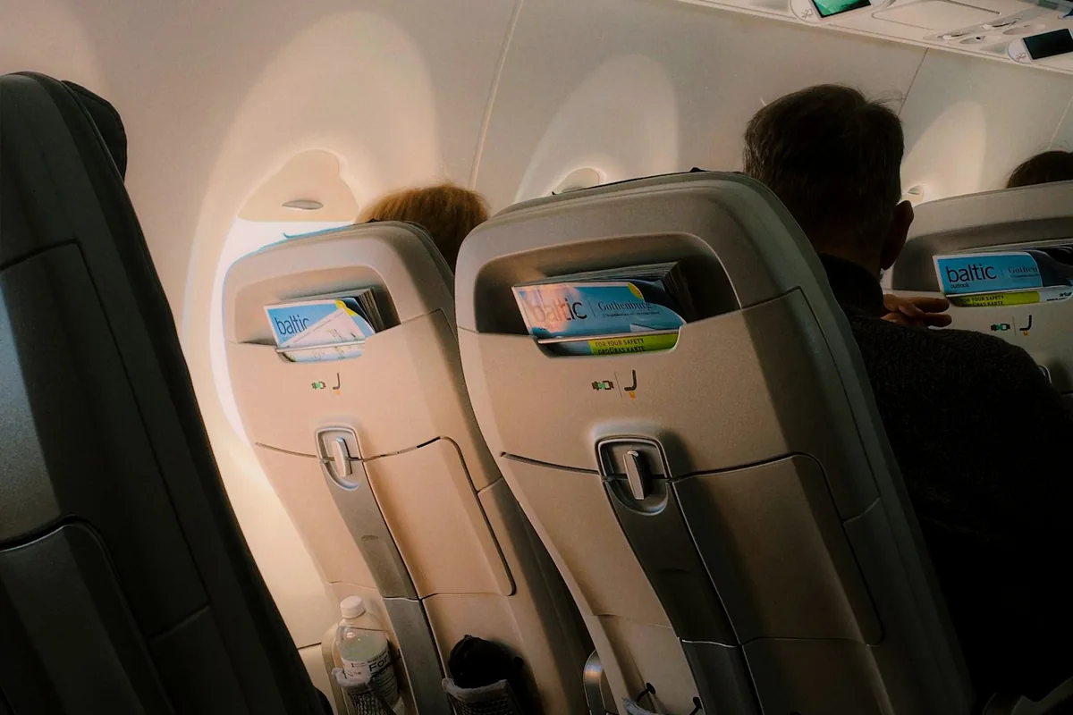 Passengers seated in a dim airplane cabin during a flight