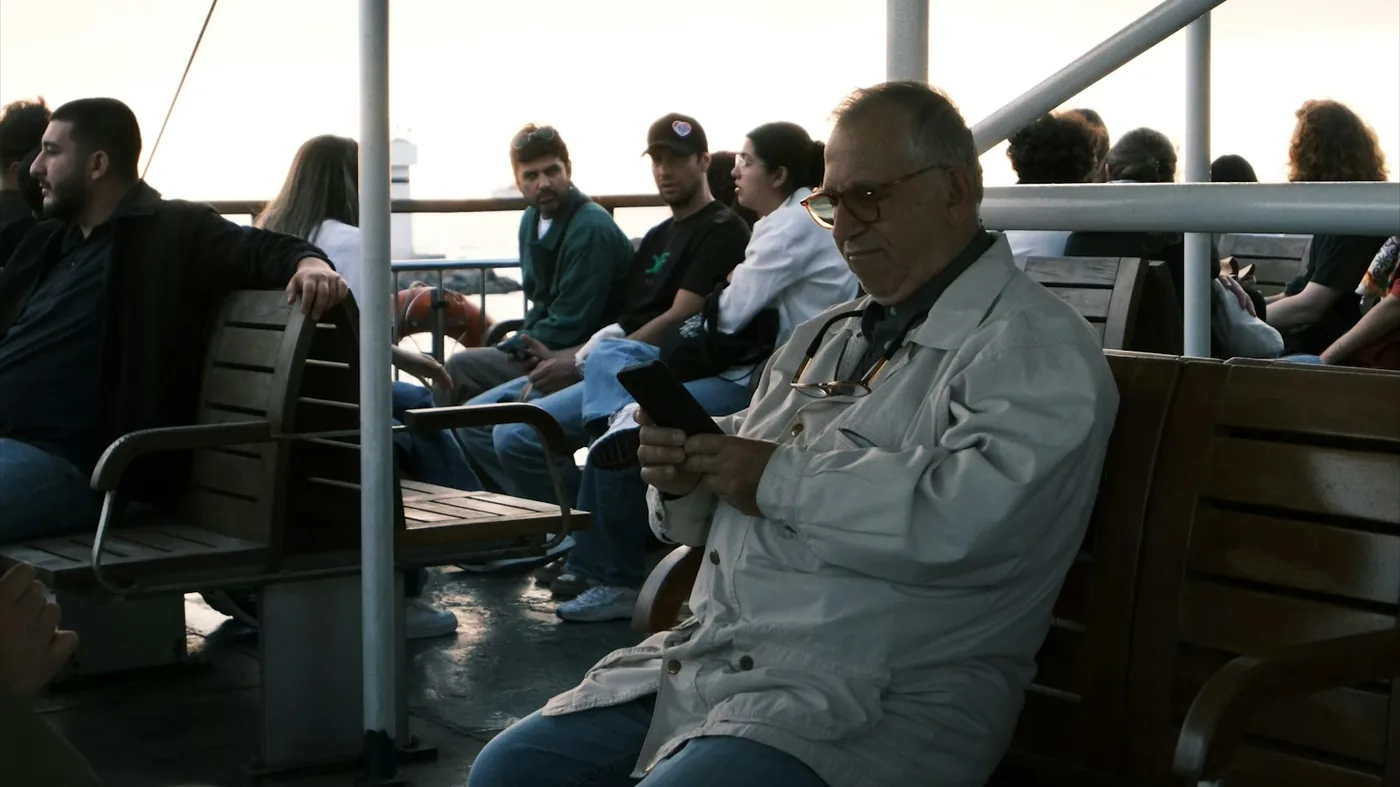 Passagiere auf einem Fährdeck schauen auf ihre Smartphones