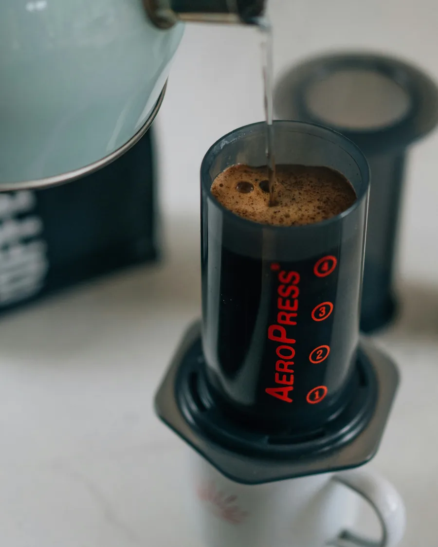Hot water pouring into an AeroPress, a travel coffee maker for remote workers