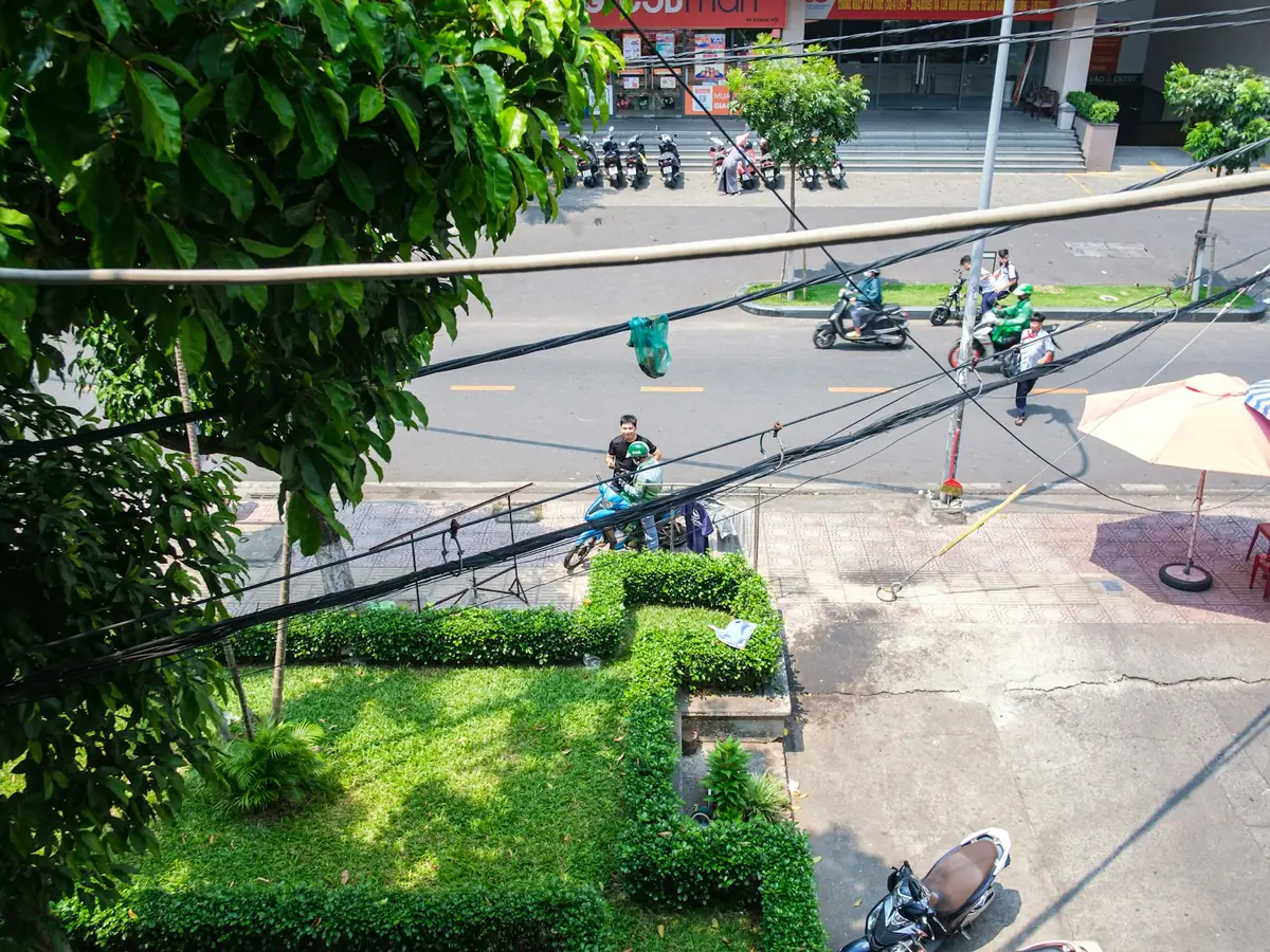 View from above of a street junction with scooters and green foliage, scooter rules in Southeast Asia