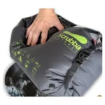 Een hand drukt op de grijze Scrubba wasbag met het wasbord aan de binnenzijde