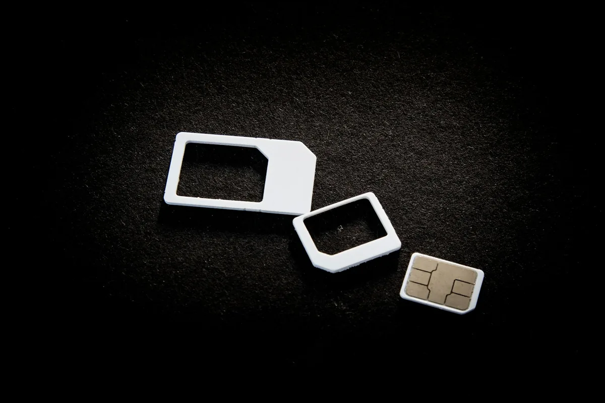 SIM cards with adapters laid out on a dark surface