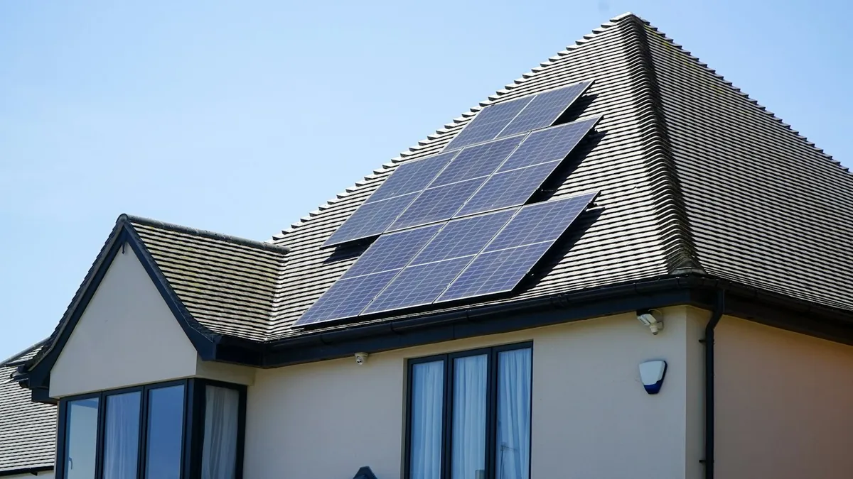 Solar panels on the tiled roof of a house under a blue sky