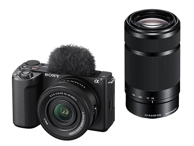 Sony ZV-E10 II vlog camera in black with fluffy windscreen and 16-50mm kit lens, next to a 55-210mm telephoto lens