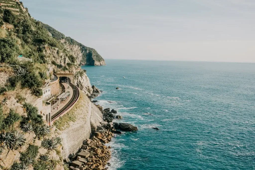 Costa rocosa y empinada con una carretera tallada en el acantilado sobre el mar