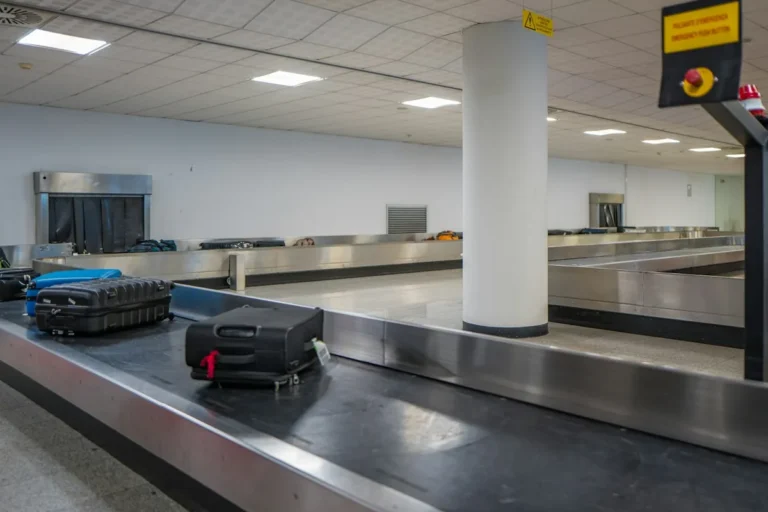 Suitcases and bags on a baggage carousel in a bright airport arrivals hall