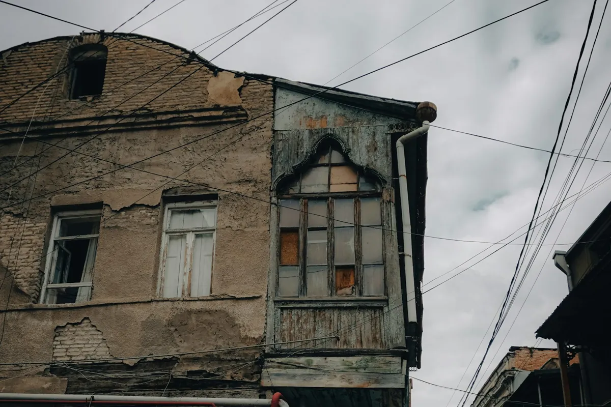 Old weathered building with a wooden balcony on a Tbilisi street
