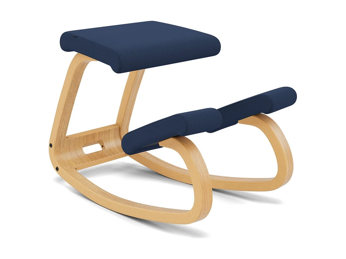 Varier Variable kneeling chair with a navy cushioned seat and knee pad on curved wooden runners