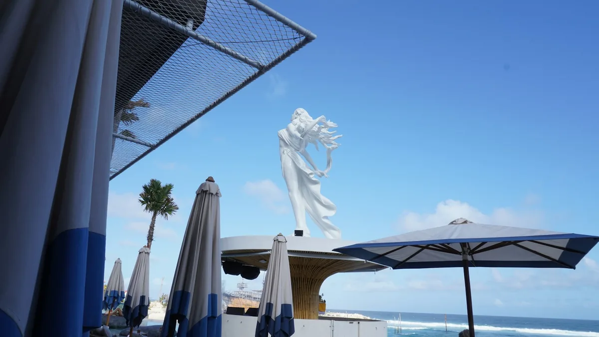 White umbrellas and a seaside terrace under a bright blue sky